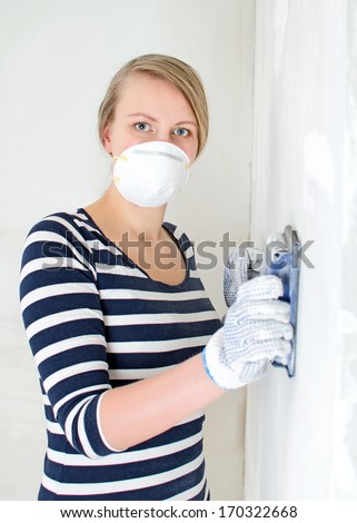 Female plasterer polishing the wall.
