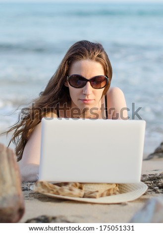 Woman with laptop working on the beach. Place for text.