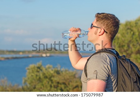 Male tourist tired. Drinking water.