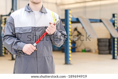 Mechanic with torque wrench at auto repair shop.