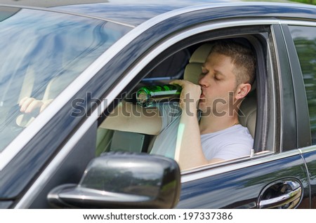 Driving Under the Influence. Man drinking alcohol in the car.