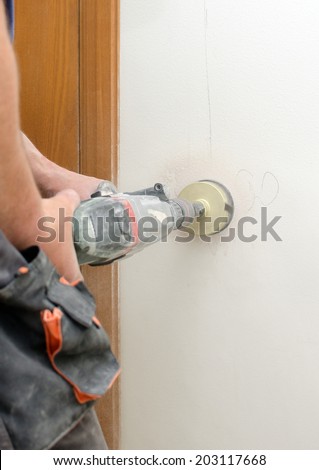 Man with Hammer drill doing hole for socket.