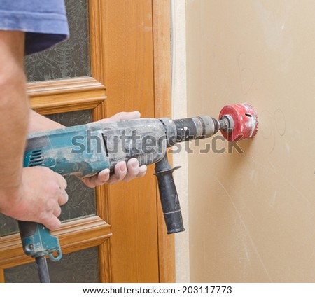 Man with Hammer drill doing hole for socket.