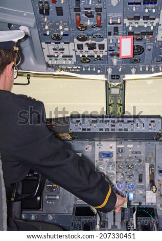 Rear view of pilot in aircraft cabin.