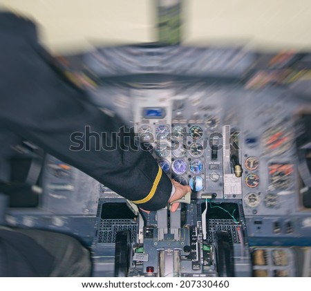 Rear view of pilot in aircraft cabin. Motion effect.