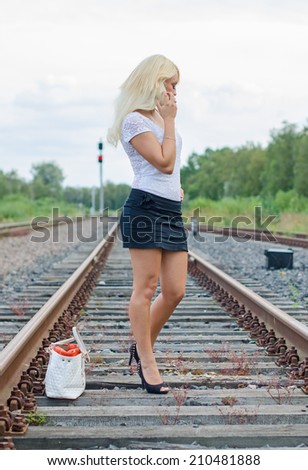 Woman missed the train. Calling someone on the phone.