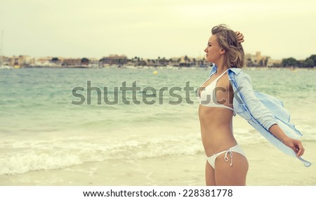 Young woman posing near the sea. Vintage effect.