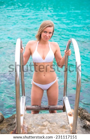 Woman in bikini going out of the sea.
