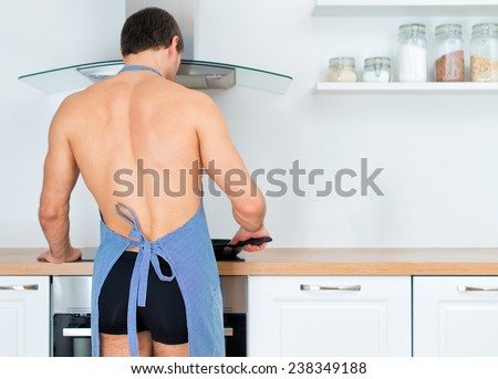 Man preparing food in the kitchen. View from the back.