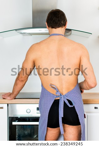 Man preparing food in the kitchen. View from the back.