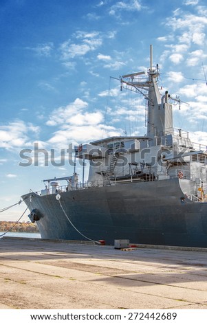 Naval auxiliary ship docked at the harbor.