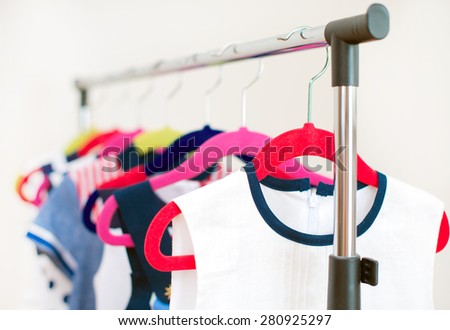 Lots of colorful dresses on hangers in shop.