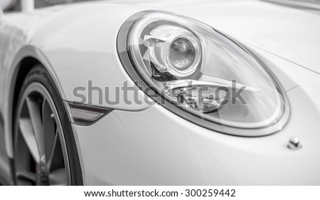 Close-up view of white sports car headlight.