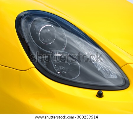 Close-up view of yellow sports car headlight.