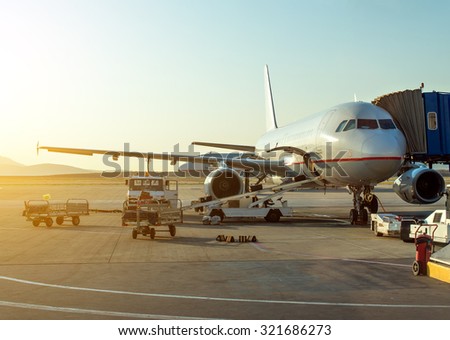 Passenger plane in the airport at sunrise. Aircraft maintenance.