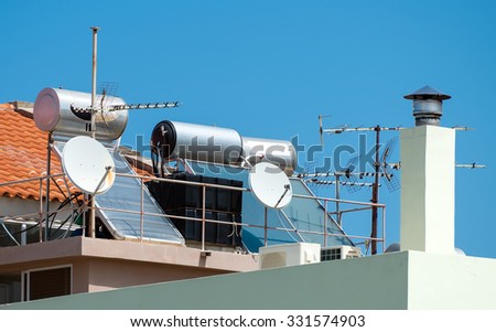 Solar water heating system and satellite television dishes on the rooftops.