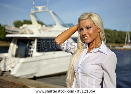 portrait of blonde girl in a white shirt against the boat