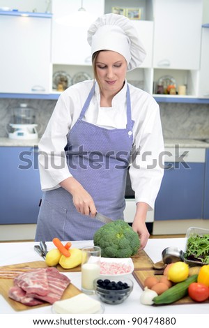 Attractive chief cook preparing food, cuts cauliflower