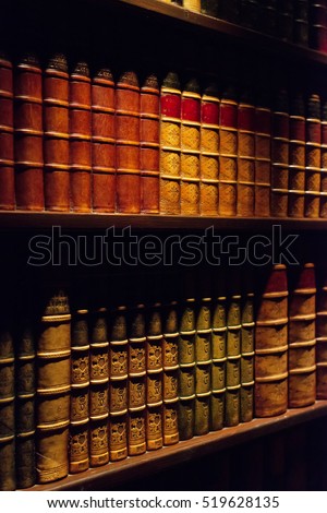 Ancient books on wooden shelf.