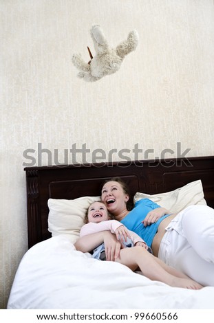 Mom and daughter having fun with a flying teddy bear toy