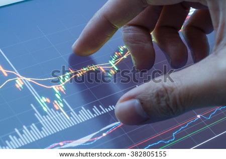 Touching stock market graph on a touch screen device. Closed up shot.