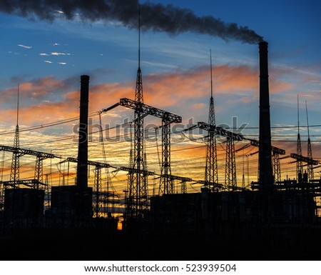 Smoke stacks at coal burning power plant, industrial silhouette