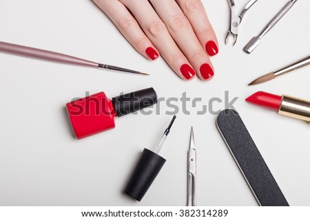 beautifully manicured nails on the desktop with tools for manicure