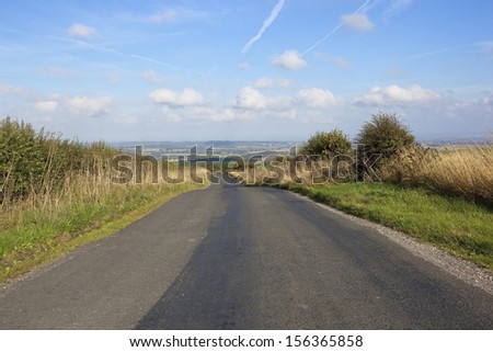 English landscape with a view along a rural highway in the picturesque landscape of the yorkshire wolds under a blue sky in late summer