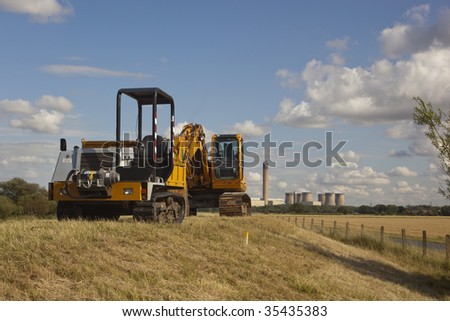 two mechanical diggers parked on a river bank ready to start work on monday