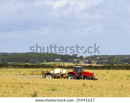 a tractor mounted crop sprayer in action in a wheatfield