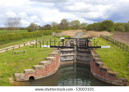 traditional wooden sluice gates controlling land drainage in an english landscape in springtime