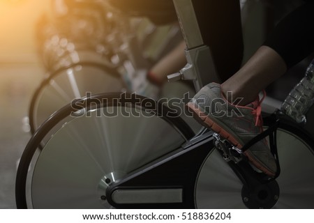 Girl doing sport biking in the gym for fitness/ cinematic tone / Made from light photo graphic / soft focus