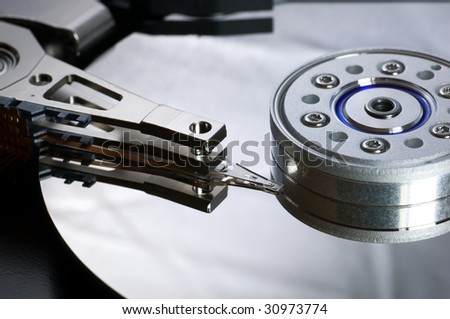 Dismantled hard drive showing platter and read/write head