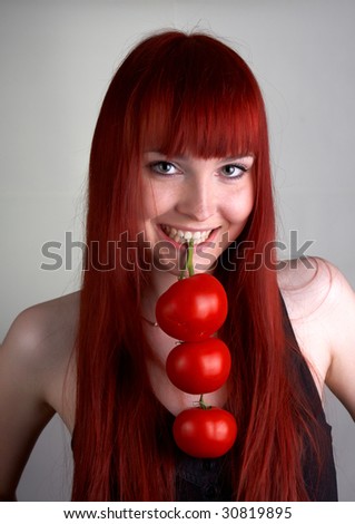 stock photo cure red head girl holding three red tomatoes branch in her 