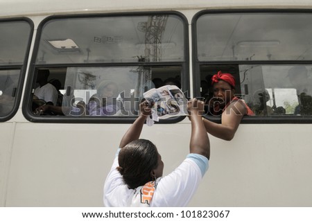 PORT-AU-PRINCE -SEPTEMBER 1: Residents asking people on bus to join in a funeral demonstration of a 6 months old baby who was burnt alive inside his tent on September 1 2010 in Port-Au-Prince, Haiti.