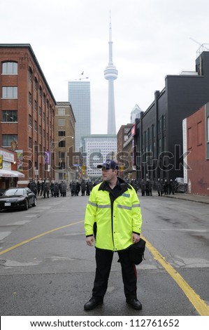 TORONTO-JUNE 26:  A Toronto police officer standing in front of a perimeter formed by the riot police  during the G20 Protest on June 26 2010 in Toronto, Canada.