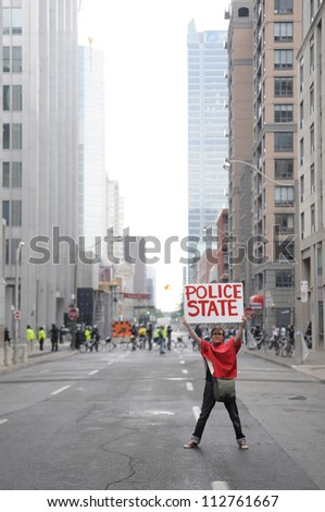 TORONTO-JUNE 26:  A protester holding a sign which says that this sate has become a 