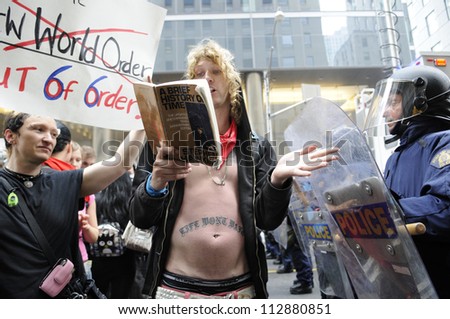 TORONTO-JUNE 26:   A protester reads out lines from a Stephen Hawking book titled \