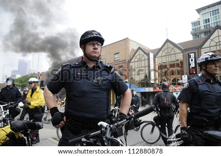 TORONTO-JUNE 26:   Police officers protecting the crime scene after a police patrol car was torched by the vandals during the G20 Protest on June 26, 2010 in Toronto, Canada.