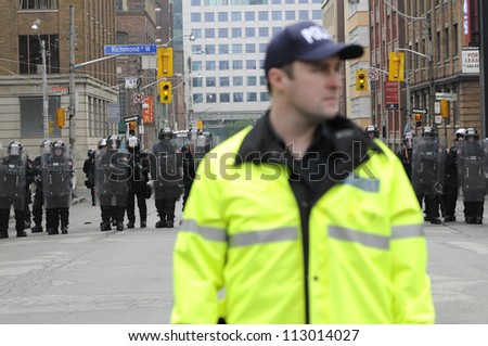 TORONTO-JUNE 26:  A police officer standing on the first line of control while other riot police officers stand on the second line during the G20 Protest on June 26, 2010 in Toronto, Canada.