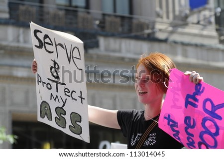 TORONTO-JUNE 25:   A protester holding a sign that mocks the catch line of the Toronto police \