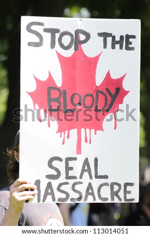 TORONTO-JUNE 25: An animal activist with a sign- protesting against the decision of the Canadian Government  to allow people to hunt seals during the G20 Protest on June 25, 2010 in Toronto, Canada.