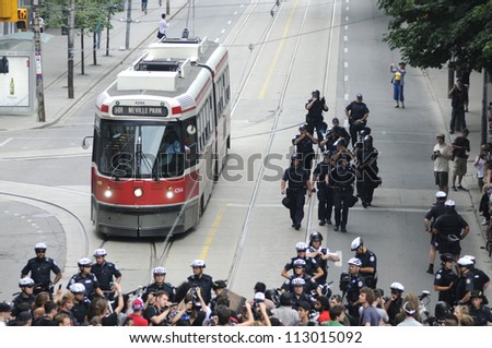 TORONTO-JUNE 28: A street car being guarded by the riot police during the G20 Protest on June 28, 2010 in Toronto, Canada.