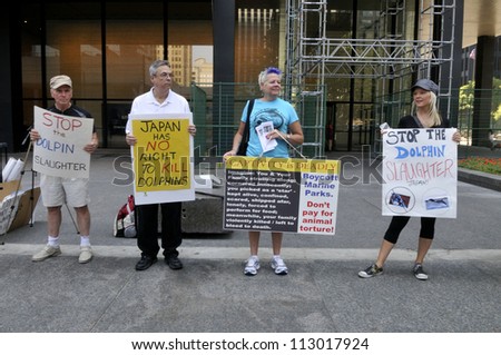 TORONTO-AUGUST 31:Protesters with signs on the sidewalks during a rally to protest the start of the annual  dolphin hunt at Taiji,Japan on August  31, 2012 in Toronto, Canada.