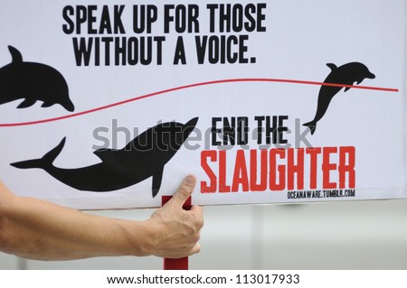 TORONTO-AUGUST 31:  A protester holds a sign asking people to speak up during a rally to protest the start of the annual  dolphin hunt at Taiji,Japan on August  31, 2012 in Toronto, Canada.