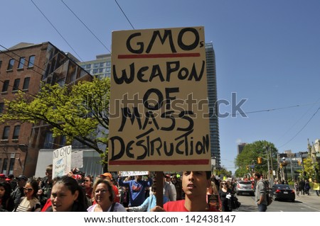 TORONTO-MAY 25: Protestors holding signs comparing Genetically modified foods as a \