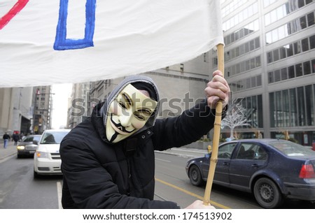 TORONTO-JANUARY 31:  A guy wearing Guy Fawkes mask during a rally to protest the proposed TPP  trade agreement and NAFTA  Agreement on January 31, 2014 in Toronto, Canada.
