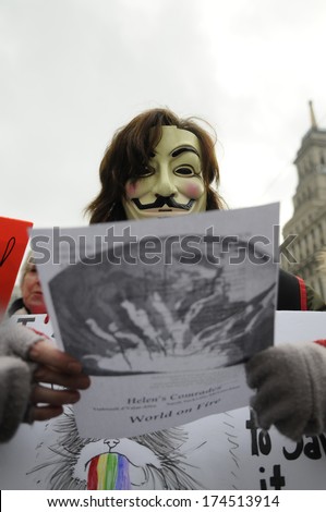 TORONTO-JANUARY 31:A girl wearing Guy Fawkes mask reading the lyrics of the song World On Fire\