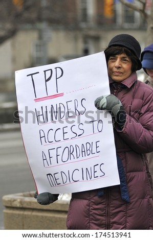 TORONTO-JANUARY 31: A protester holding sign to criticize TPP agreement  during a rally  to protest the proposed TPP  trade agreement and NAFTA  Agreement on January 31, 2014 in Toronto, Canada.