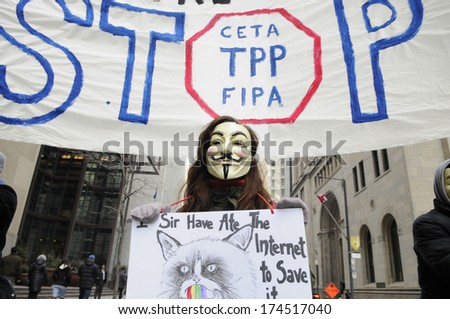 TORONTO-JANUARY 31: A supporter wearing a Guy Fawkes mask during a rally  to protest the proposed TPP  trade agreement and NAFTA  Agreement on January 31, 2014 in Toronto, Canada.